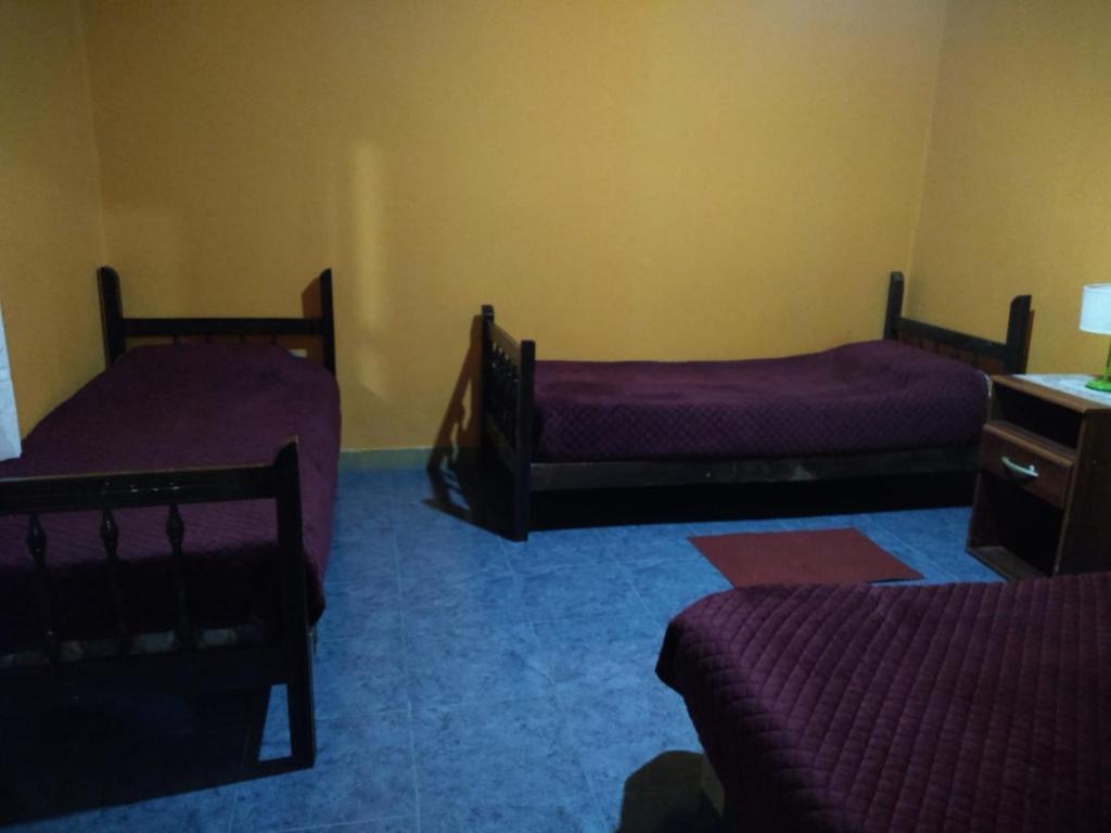 Habitación con 2 camas, tocador y escritorio. en Hosteria M.G en Tilcara