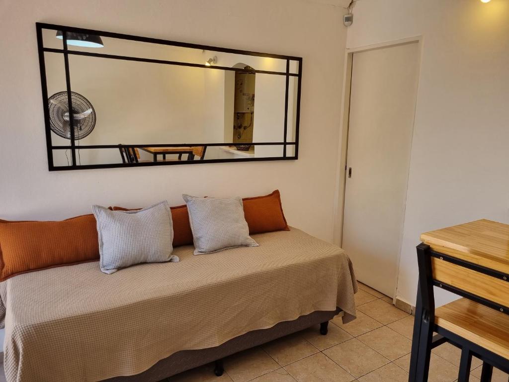 - une chambre avec un lit et un miroir mural dans l'établissement El Refugio departamento 2, à Luján