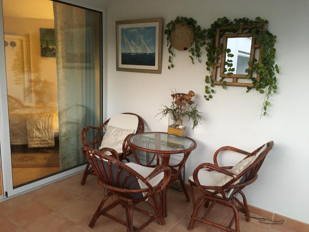 una mesa de cristal con sillas y un espejo en la pared en Marbella Apartment, en Marbella