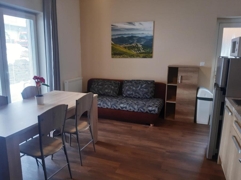 - un salon avec une table et un canapé dans l'établissement Apartments Lucky Jasna - Apartmánový Dom 188 Apartment Nr. 5, à Demänovská Dolina