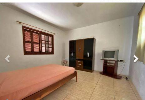 1 dormitorio con 1 cama y TV. en Casa Leivas, en Río Grande