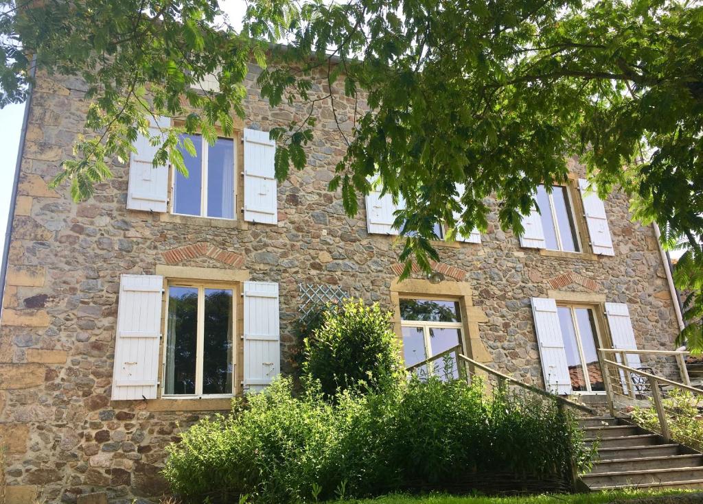 an old stone building with white shuttered windows at "La Maison de Villars" au coeur de la nature in Pressac