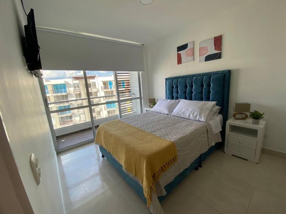 Un dormitorio con una cama azul y una ventana en Tu Descanso Ideal, en Ricaurte