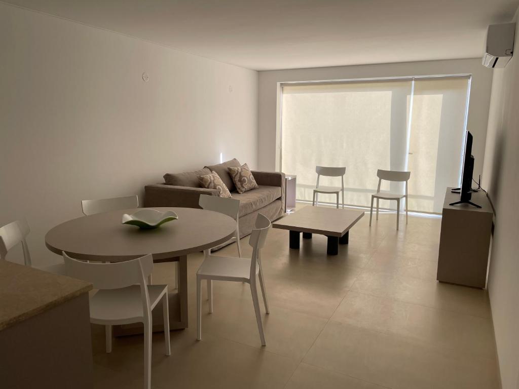 uma sala de estar com um sofá, uma mesa e cadeiras em ROCAS DEL PLATA 2 (Mendoza Capital) em Mendoza