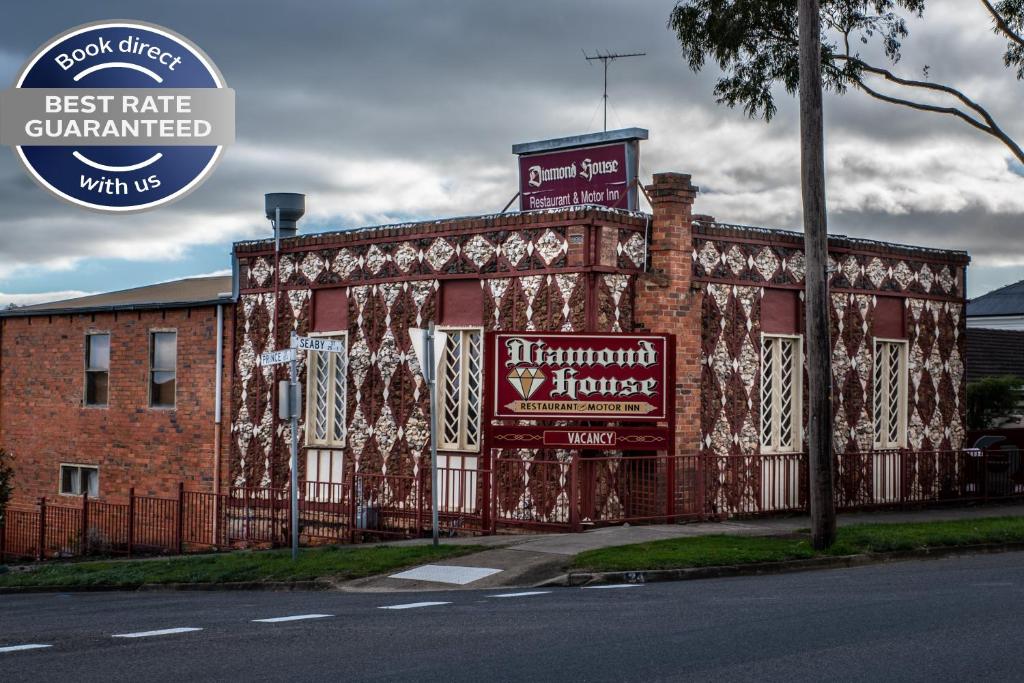 ein großes rotes Backsteingebäude mit einem Schild darauf in der Unterkunft Diamond House Heritage Restaurant and Motor Inn in Stawell