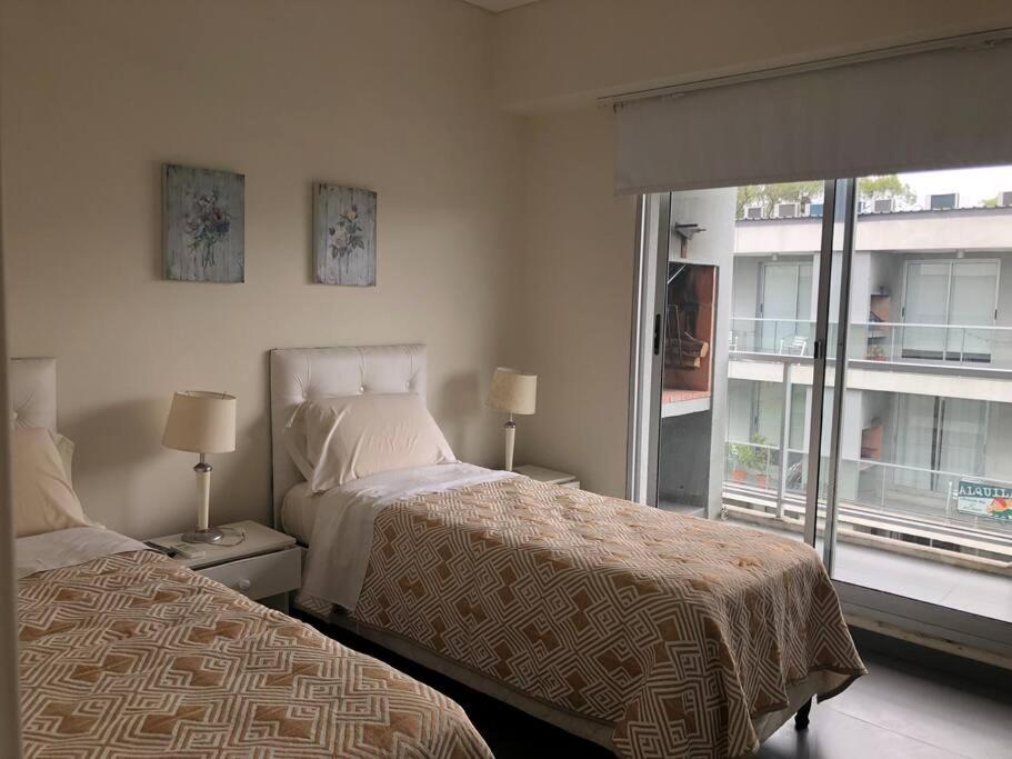 1 dormitorio con 2 camas y ventana grande en Moderno Loft en Termas del Daymán, en Salto