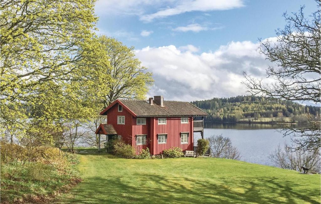 a red house on a hill next to a lake at Awesome Home In Dals Lnged With House Sea View in Dals Långed