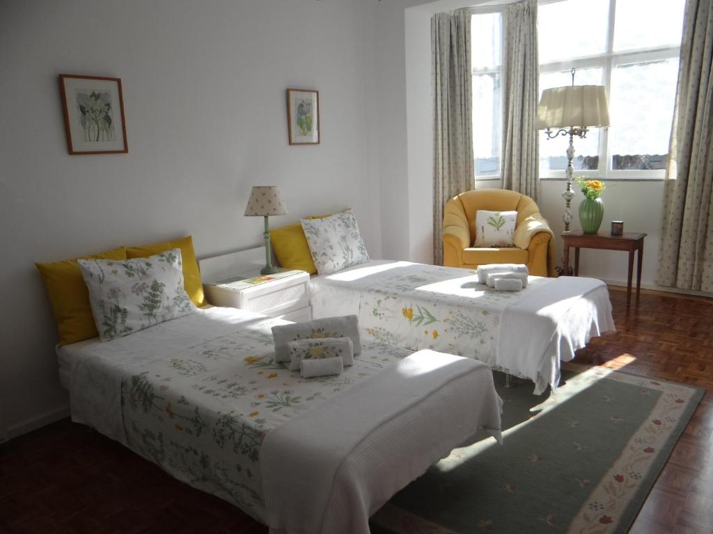 1 dormitorio con 2 camas, silla y ventana en Meet Porto Apartment, en Matosinhos
