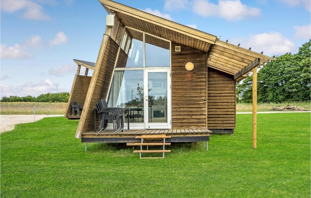 a tiny house with a porch and chairs on the grass at Cozy Home In Kolding With Kitchen in Kolding