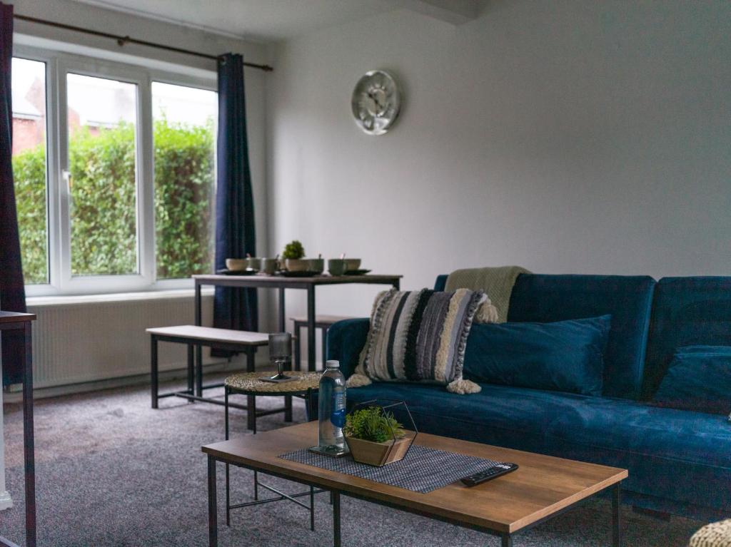 a living room with a blue couch and a table at Beautiful Durham accommodation - Perfect for contractors in Shincliffe