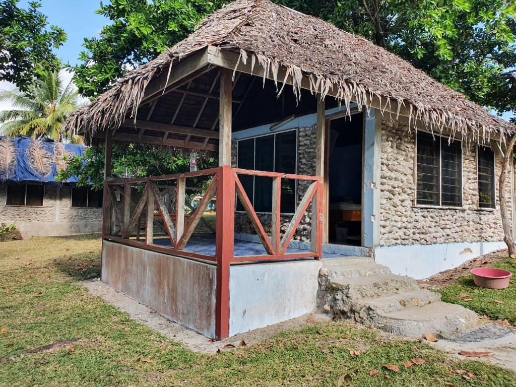 una pequeña casa con techo de paja en Lonnoc Beach Lodge en Hog Harbour