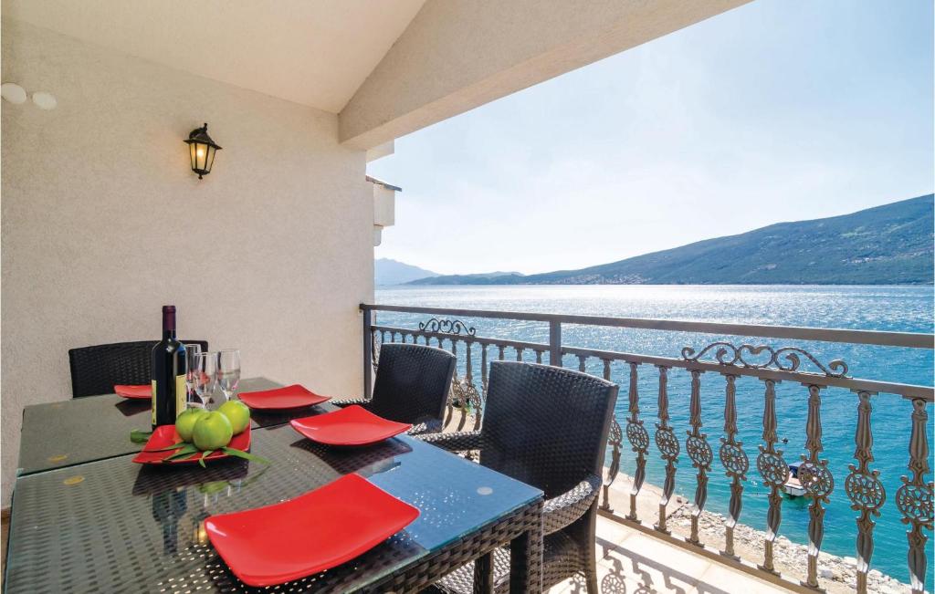 a table on a balcony with a view of the water at Apartment Baosici Baosici in Herceg-Novi