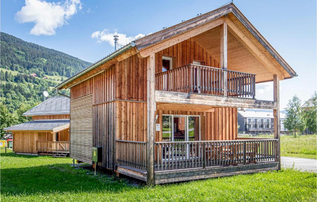 a wooden house with a balcony on a green field at Stunning Home In St,georgen Am Kreischb, With 2 Bedrooms And Sauna in Sankt Lorenzen ob Murau