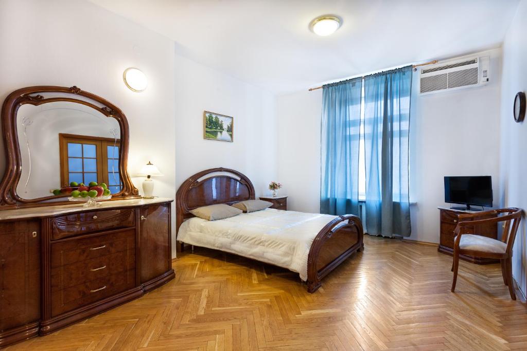 a bedroom with a bed and a dresser and a mirror at Kruazi on Kutuzovsky in Moscow