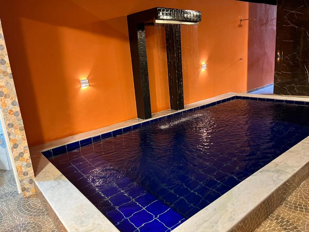 una piscina en una habitación con azulejos azules en MaragogiMeuCaribe, en Maragogi