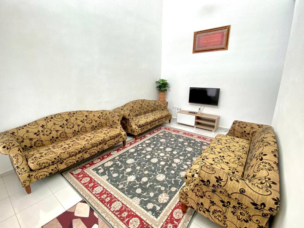 een woonkamer met een bank en een tv bij Nasrah Homestay Alor Gajah in Kampong Alor Gajah