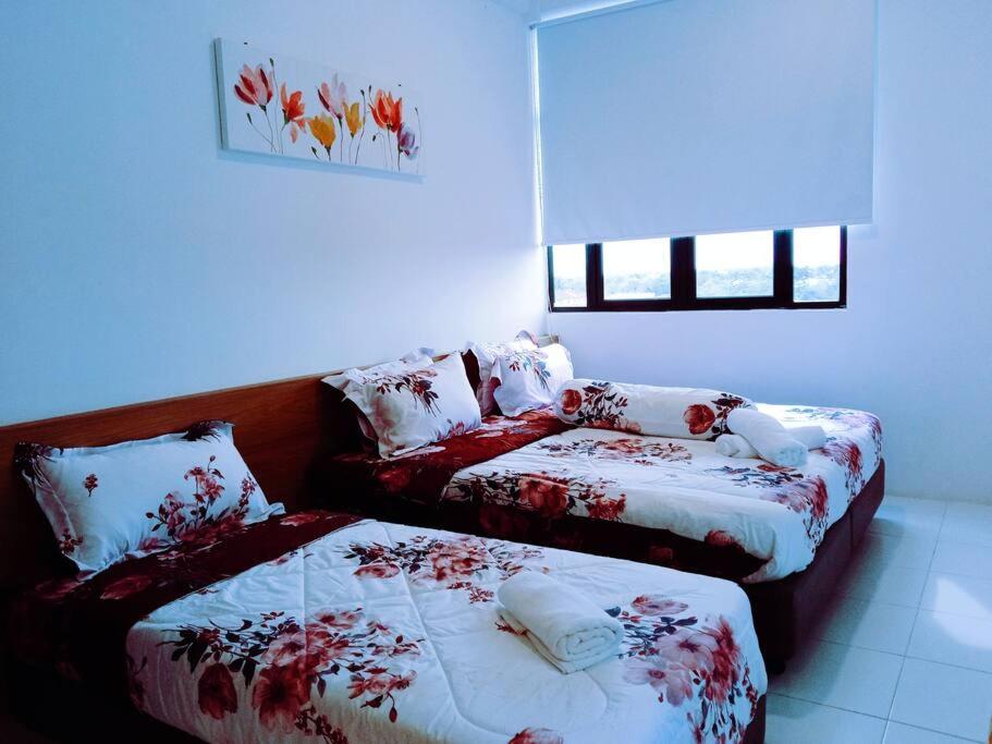 a room with two beds and a couch in it at D'yana Imperio Homestay in Alor Setar