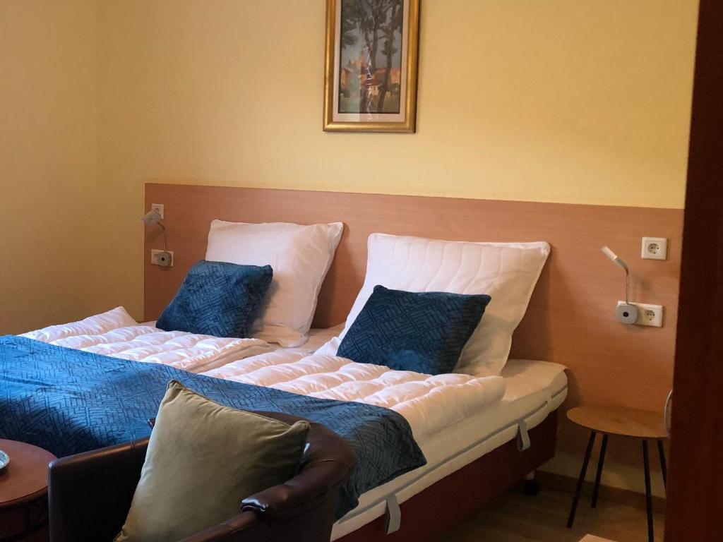 sypialnia z 2 łóżkami i niebieskimi poduszkami w obiekcie Limburger MiKa Zimmer & Garten & E-Ladestation w mieście Limburg an der Lahn