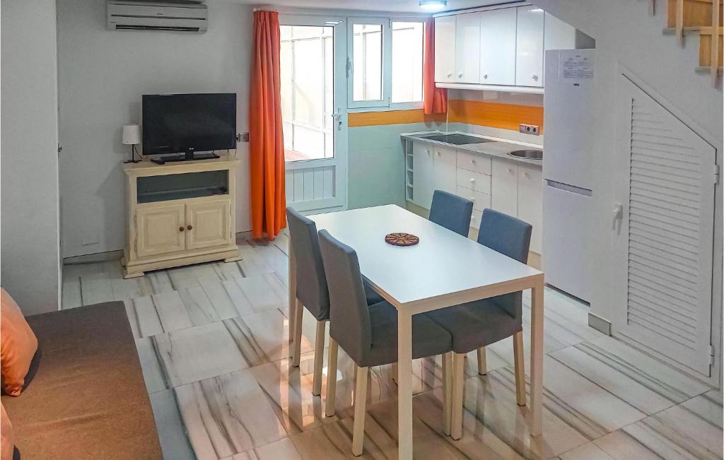 a kitchen with a table and chairs and a television at Cozy Apartment In Torremolinos With Wifi in Torremolinos
