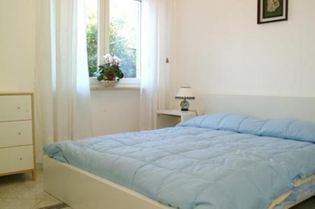 a bedroom with a blue bed with a window at Villa Orchidea in Sorrento