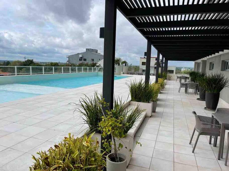 un patio con mesas y sillas y una piscina en Departamento en Sky Tower, en Asunción