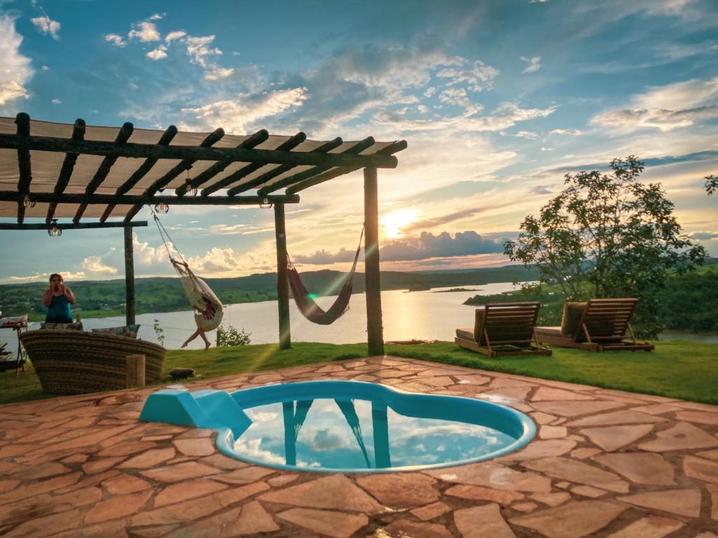 a patio with a swing and a hammock at Chalé Mirante, piscina, cachoeira, lago e vista espetacular in Alexânia