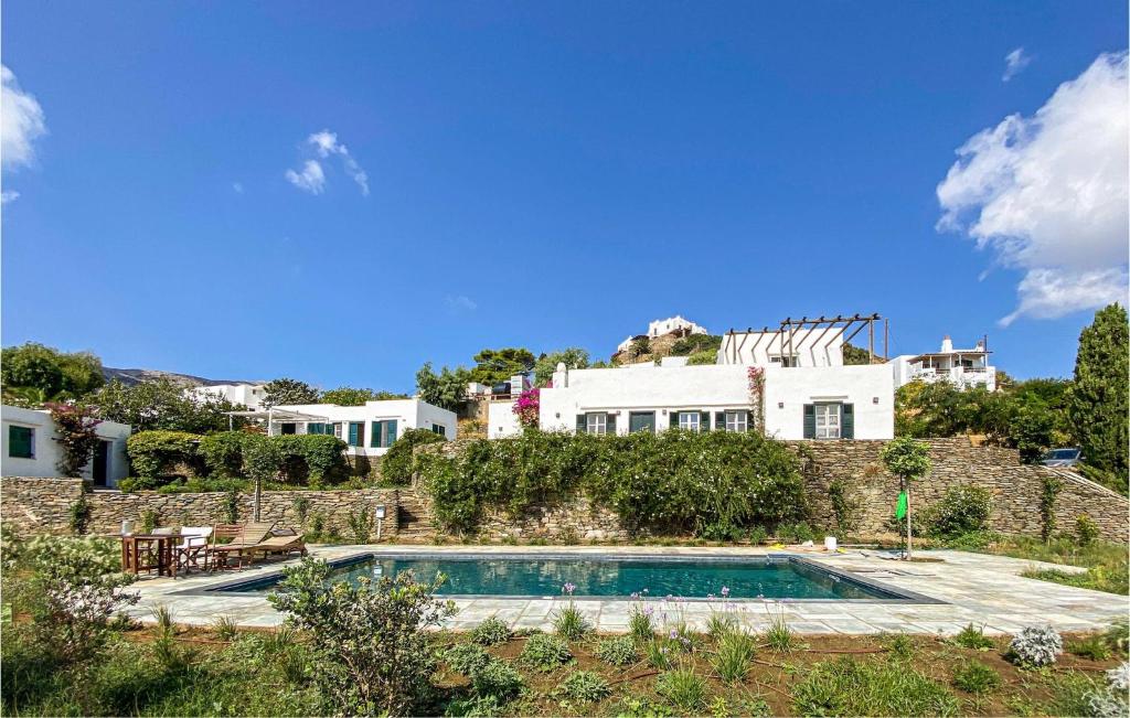 une villa avec une piscine en face d'une maison dans l'établissement Stunning Home In Sifnos With House Sea View, à Sifnos