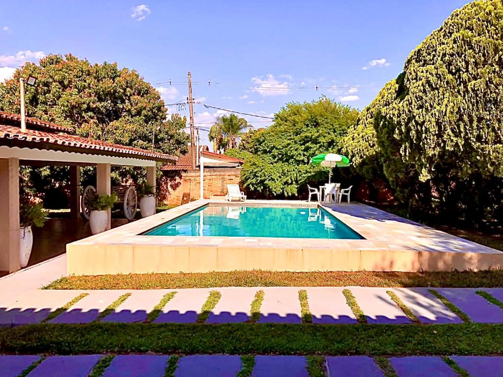 ein Swimmingpool in einem Hof mit einem Haus in der Unterkunft Chácara do Zizi in Elias Fausto