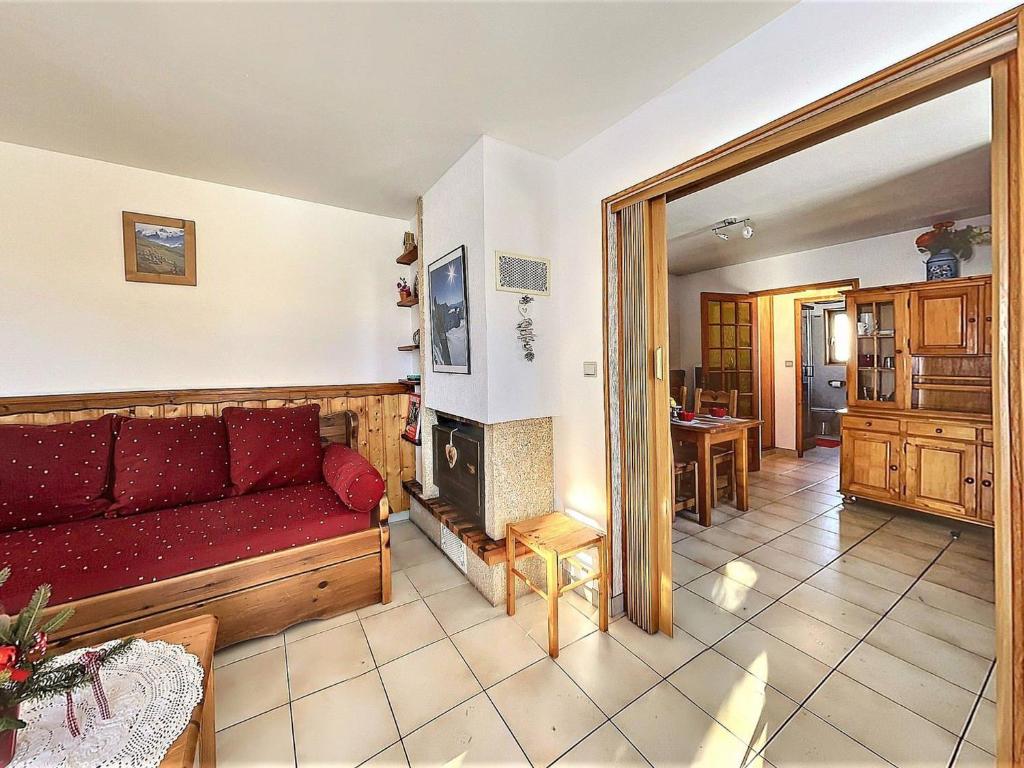 - un salon avec un canapé rouge et une cheminée dans l'établissement Appartement Le Corbier, 3 pièces, 4 personnes - FR-1-267-246, à Villarembert