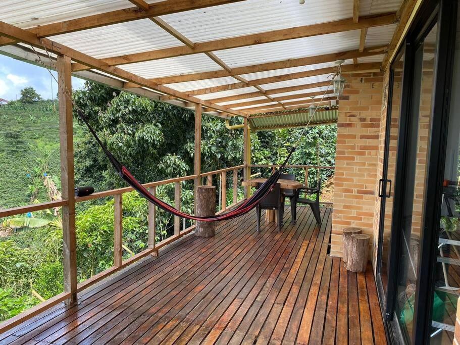 a hammock on the deck of a house at Meraki in Pereira