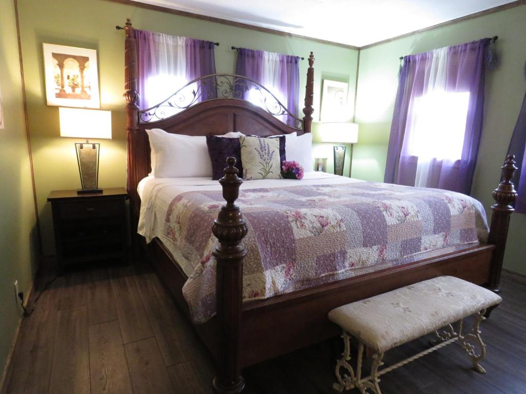 um quarto com uma cama grande e cortinas roxas em Tall Pines Inn em Eureka Springs