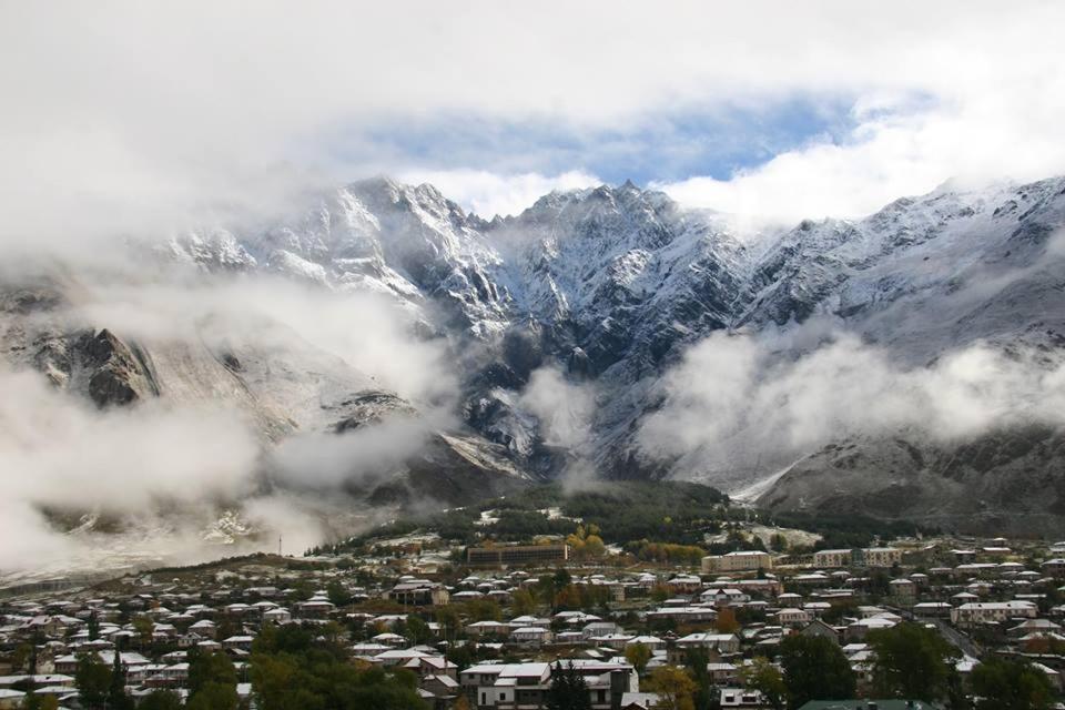 une ville en face d'une montagne enneigée dans l'établissement HQ of Nove Sujashvili, à Kazbegi