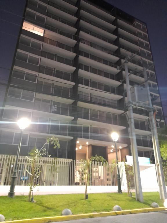 ein hohes Gebäude mit Lichtern davor in der Unterkunft Arriendo hermoso departamento in Santiago