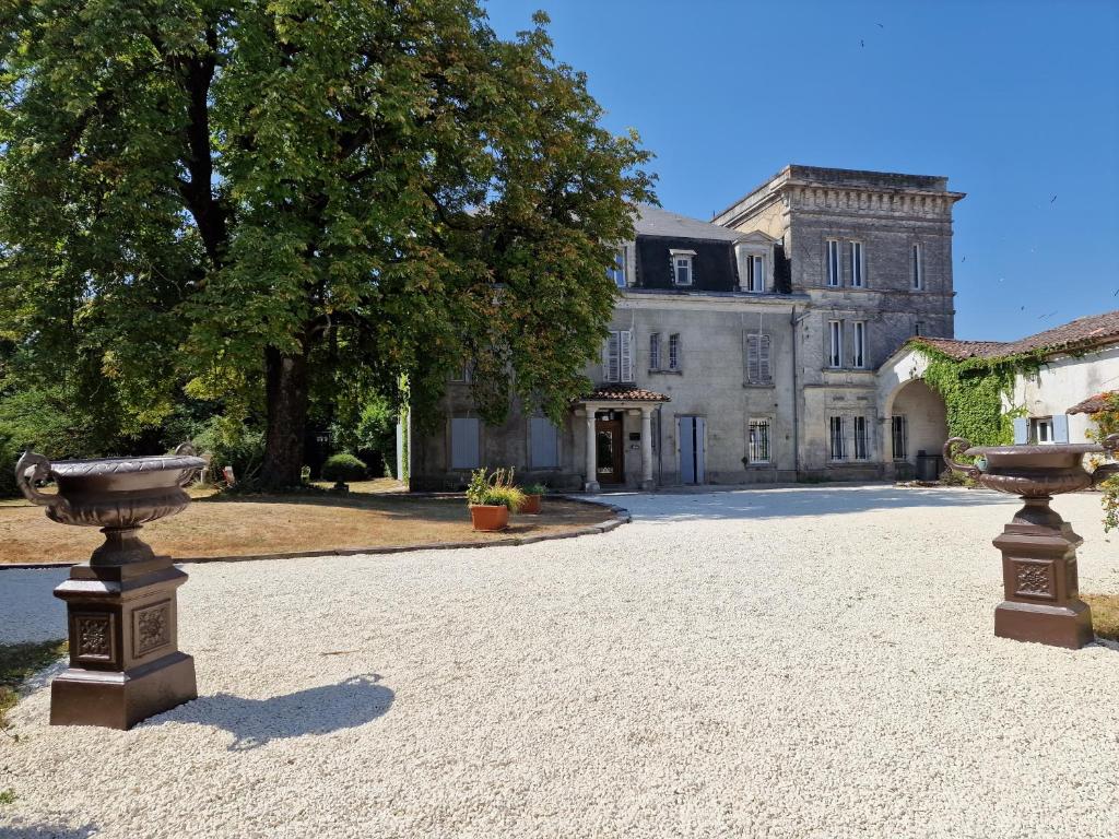 an estate with two urns in front of a building at Château de Champblanc in Cherves-de-Cognac