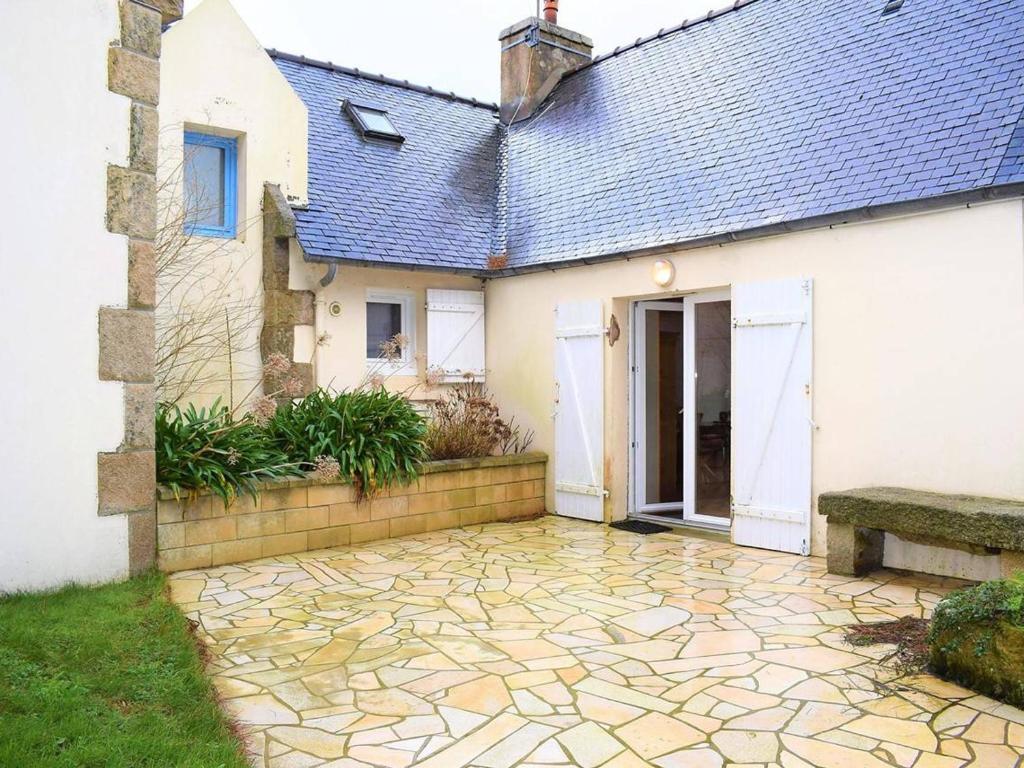 una casa con un patio de piedra frente a ella en Maison Trébeurden, 3 pièces, 5 personnes - FR-1-368-71, en Trébeurden