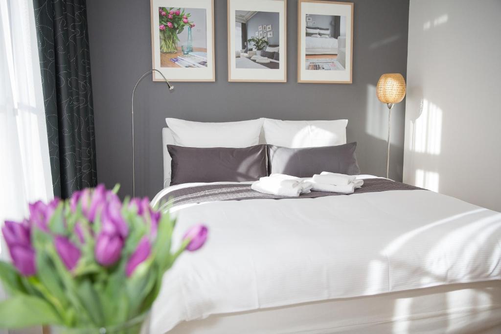 a bedroom with a white bed with a vase of flowers at Studio 44 in Leipzig