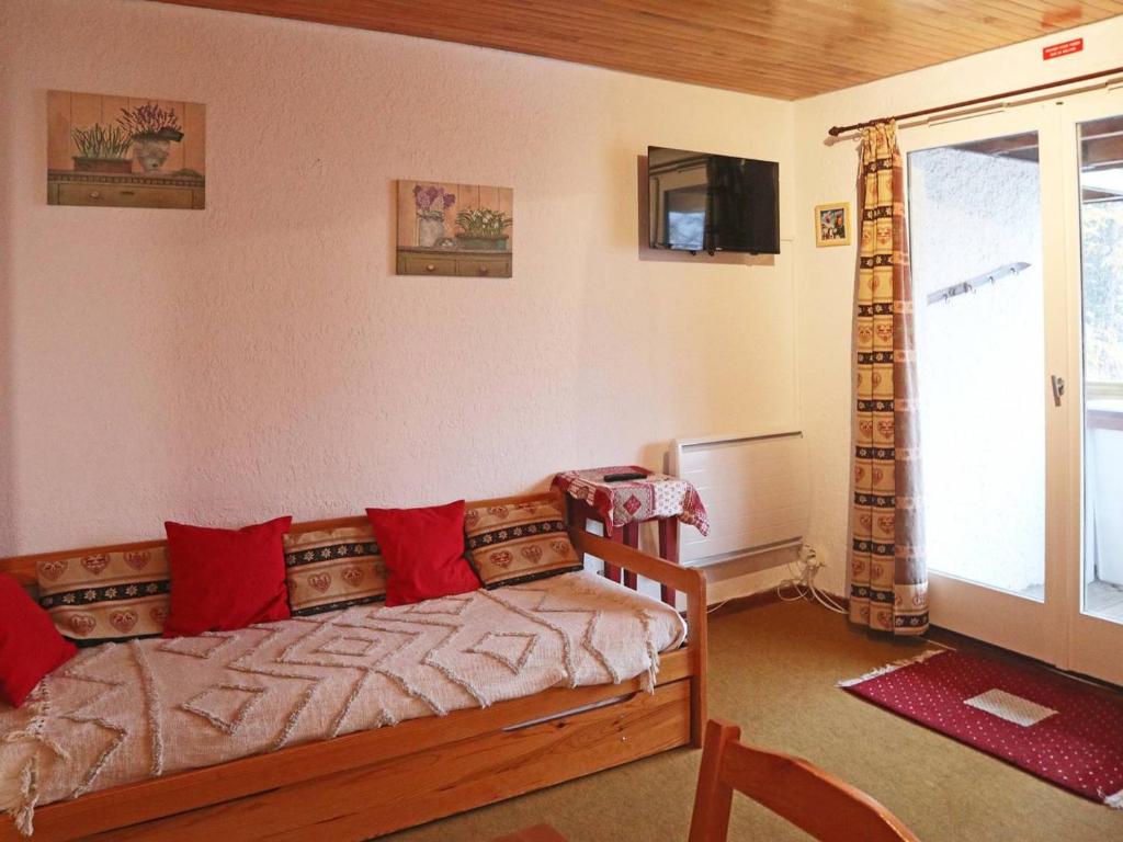 a room with a couch with red pillows and a window at Appartement Les Orres, 1 pièce, 4 personnes - FR-1-322-470 in Les Orres