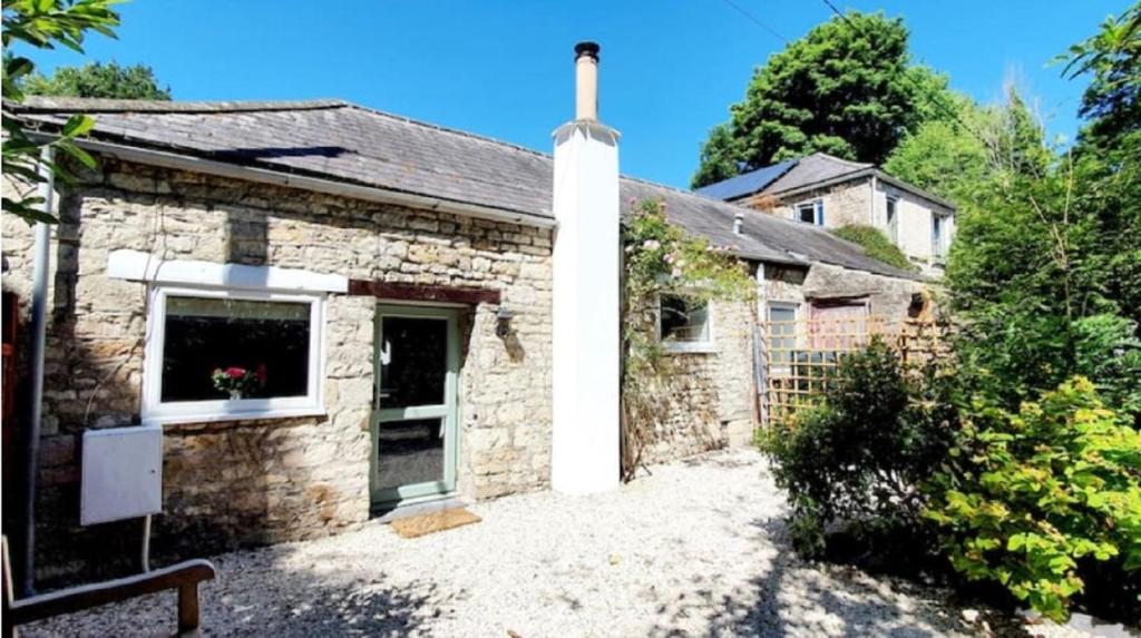 a stone house with a window and a driveway at The Annexe in Radstock