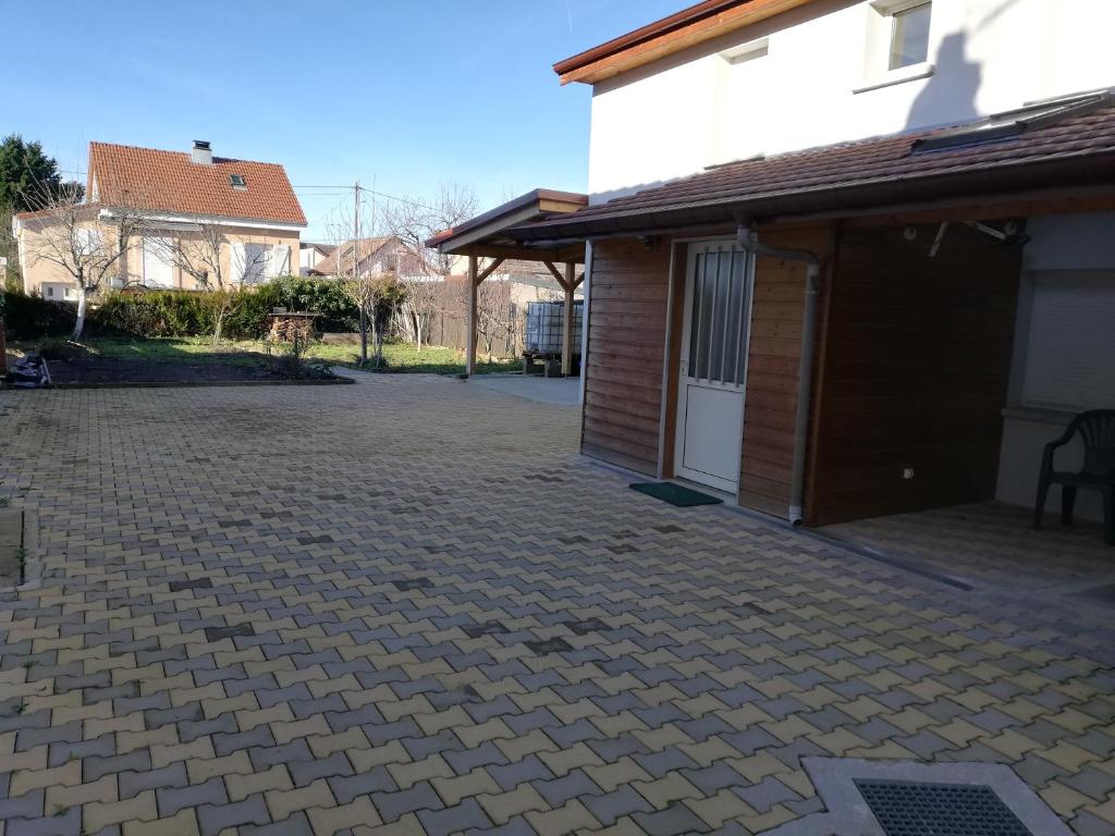 une allée en briques avec un garage à côté d'une maison dans l'établissement L'appart des Sotrés, à Saint-Dié-des-Vosges