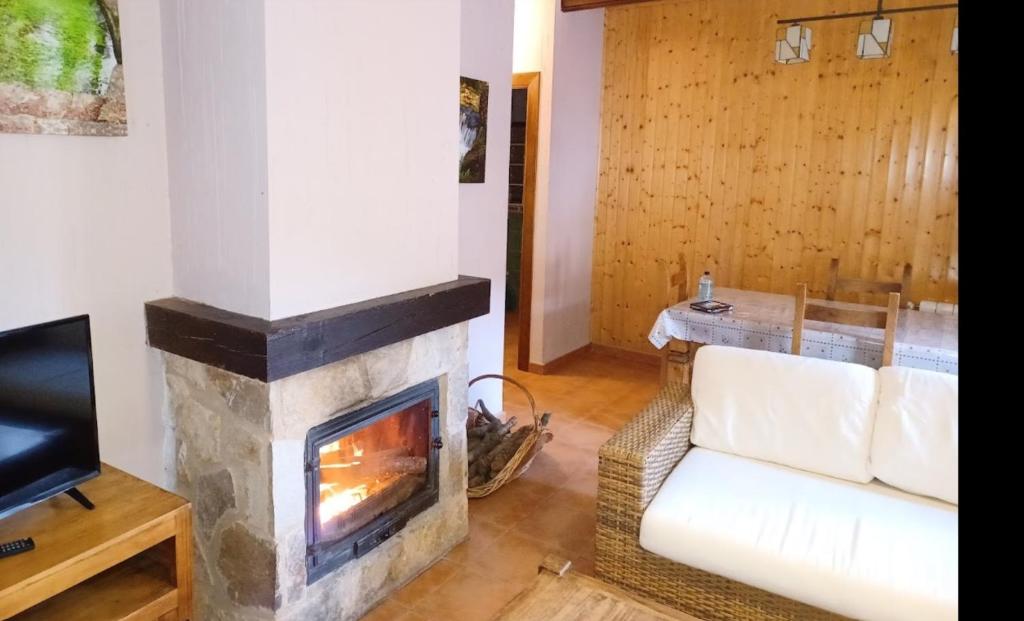 a living room with a fireplace and a couch at Ciudad Encantada Tio Daniel in Valdecabras