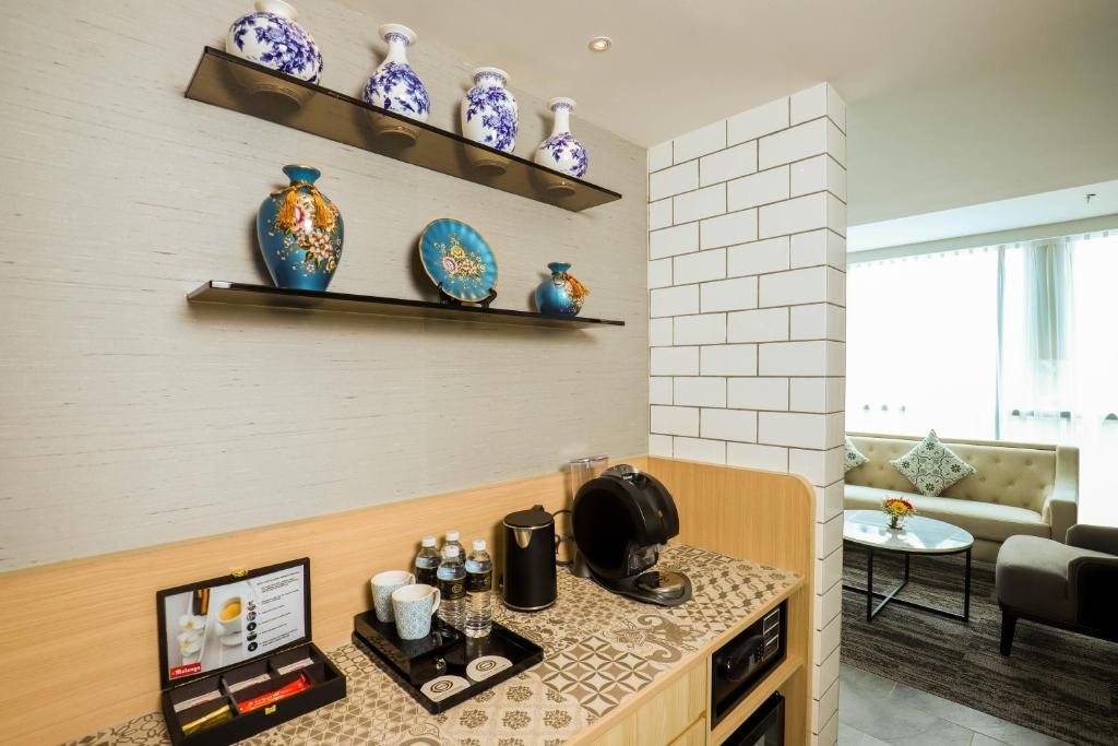 A kitchenette and beverage counter decorated with ceramic vases beside the sitting room.