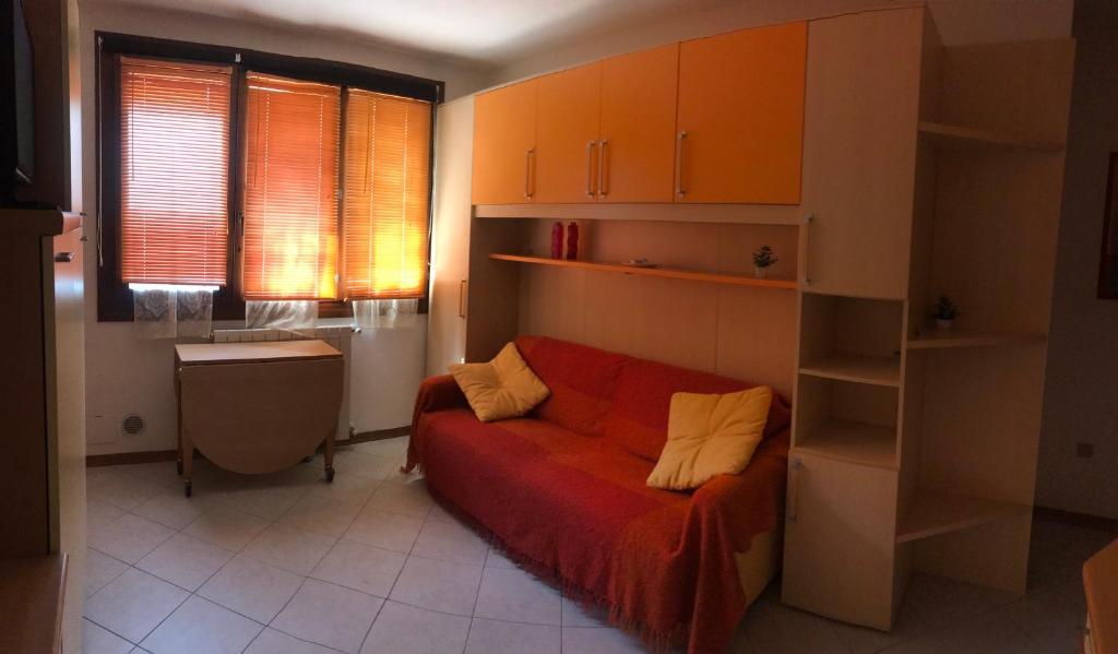 a living room with a red couch with yellow pillows at Ruscello apartment in Abetone