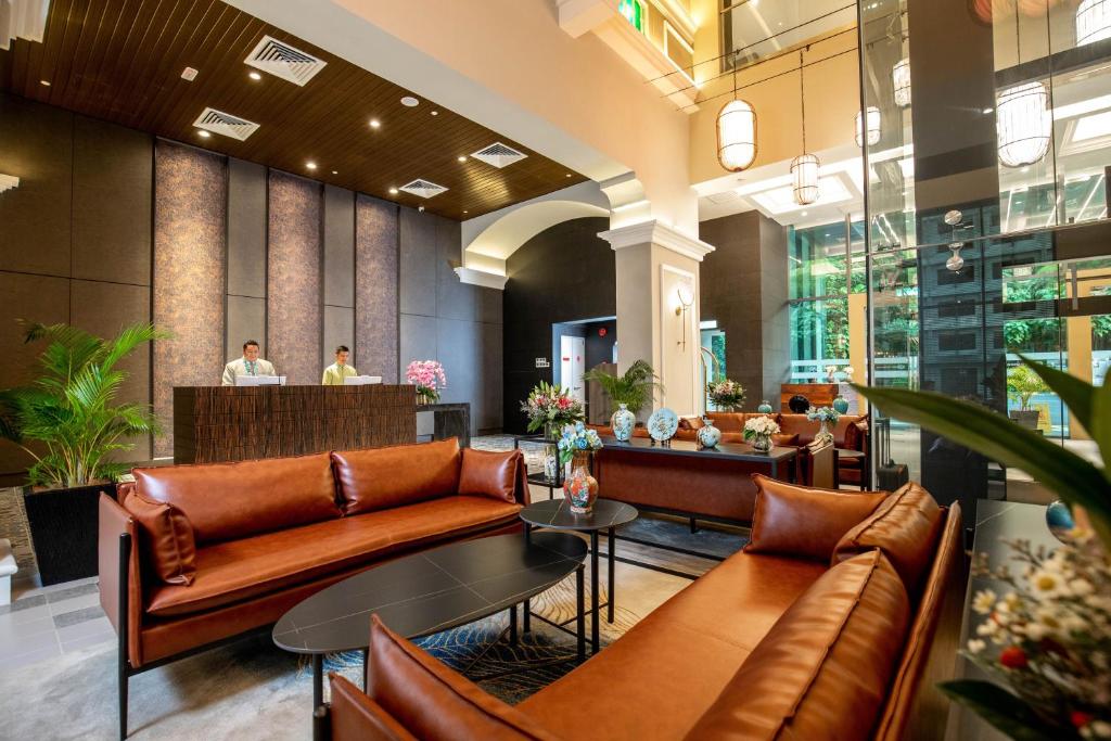 Leather sofas and a low coffee table face the hotel reception desk in a warm lobby.
