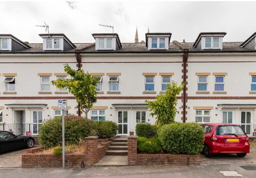a red car parked in front of a white building at White House in Bournemouth