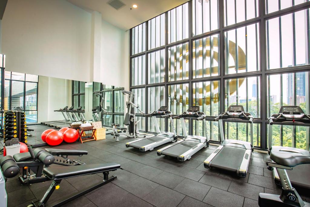 A bright, windowed fitness room with treadmills and strength equipment.
