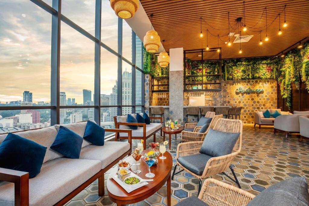 a hotel lobby with a couch and tables and chairs at Santa Grand Signature Kuala Lumpur in Kuala Lumpur