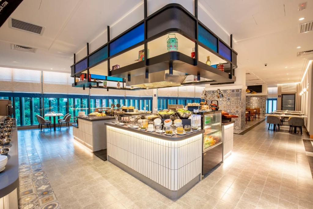 A bright buffet dining room centers on a large island counter with prepared food and drinks.