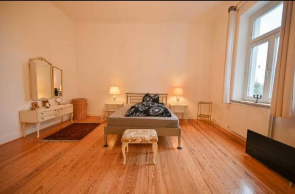 - une grande chambre avec un lit et une grande fenêtre dans l'établissement Weiße Villa 1, à Duderstadt