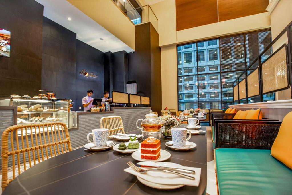 A prepared breakfast table in a bright hotel dining room.