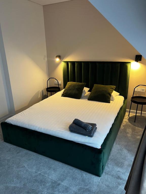 Un dormitorio con una cama grande con una toalla azul. en Pajūrio Gintaro namai en Palanga